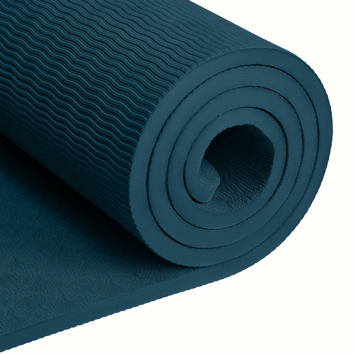 Close-up of a tightly rolled Ocean Blue textured Zuma Yoga Mat with wavy patterned surface on a white background.