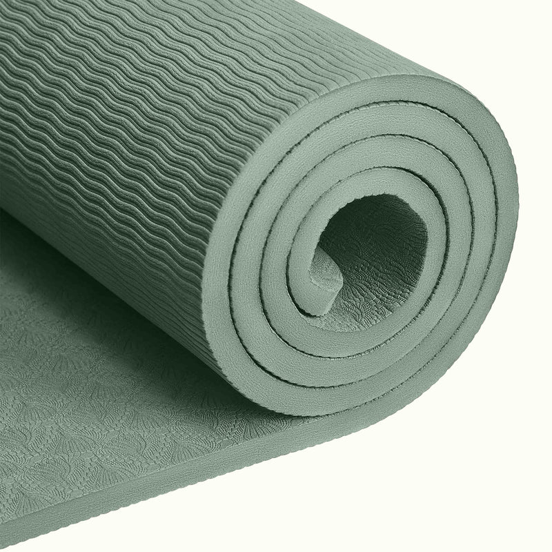 Close-up of a tightly rolled Sage textured Zuma Yoga Mat with wavy patterned surface on a white background.